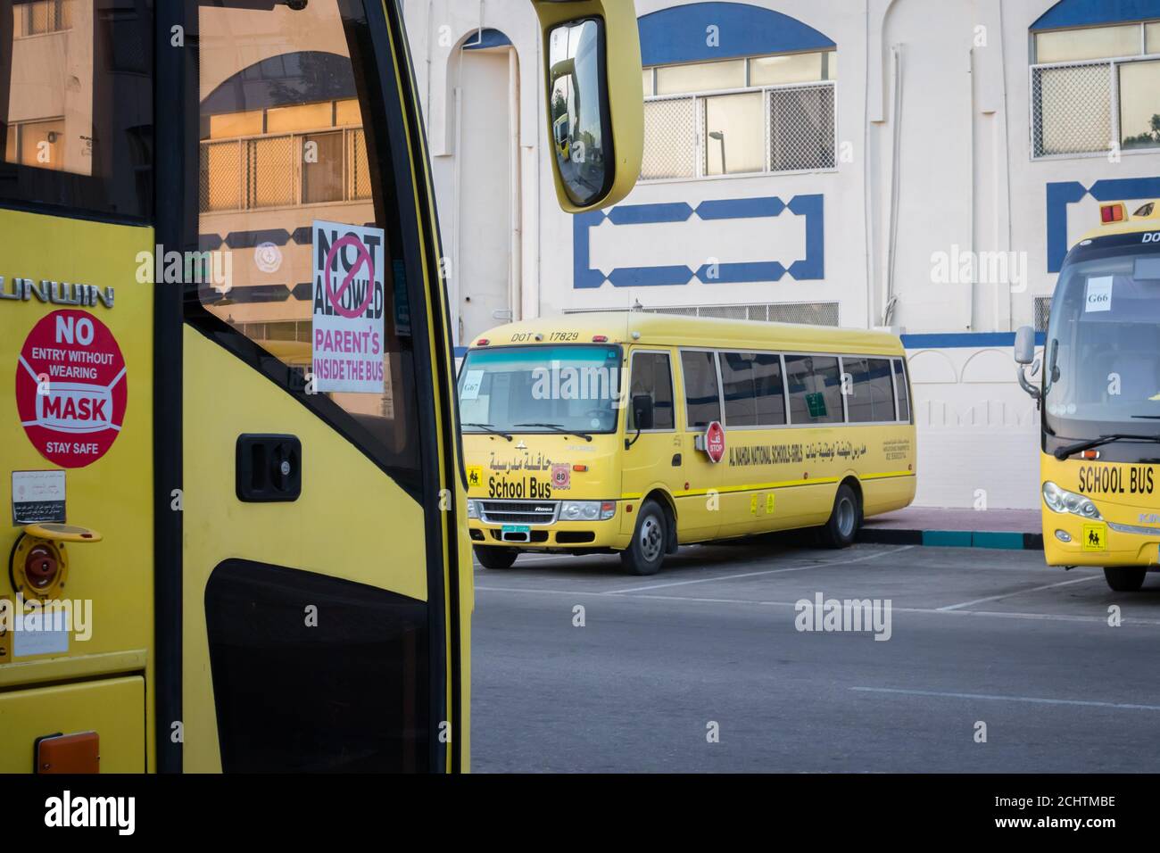 Yellow school bus in Abu Dhabi, United Arab Emirates, Dubai, Emirates, Gulf, Middle east. Awareness signs and symbol was written in arabic language at Stock Photo