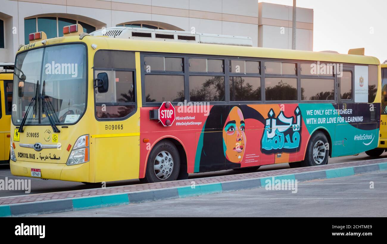 Yellow school bus in Abu Dhabi, United Arab Emirates, Dubai, Emirates, Gulf, Middle east. Awareness signs and symbol was written in arabic language at Stock Photo