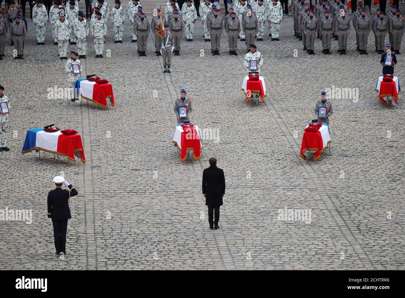 French President Emmanuel Macron pays his respect in front of the flag-draped coffins of the thirteen French soldiers killed in Mali, during a ceremony at the Hotel National des Invalides in Paris, France, December 2, 2019. French soldiers Julien Carrette, Benjamin Gireud, Romain Salles de Saint-Paul, Clement Frison-Roche, Nicolas Megard, Romain Chomel de Jarnieu, Pierre Bockel, Alex Morisse, Jeremy Leusie, Alexandre Protin, Antoine Serre, Valentin Duval, Andrei Jouk died in Mali when their helicopters collided in the dark last week as they hunted for Islamist militants.  REUTERS/Charles Plati Stock Photo