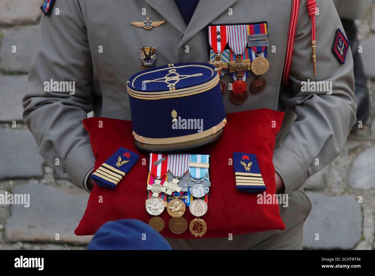A soldier carries the medals and the kepi of one of the thirteen French soldiers killed in Mali, during a ceremony at the Hotel National des Invalides in Paris, France, December 2, 2019. French soldiers Julien Carrette, Benjamin Gireud, Romain Salles de Saint-Paul, Clement Frison-Roche, Nicolas Megard, Romain Chomel de Jarnieu, Pierre Bockel, Alex Morisse, Jeremy Leusie, Alexandre Protin, Antoine Serre, Valentin Duval, Andrei Jouk died in Mali when their helicopters collided in the dark last week as they hunted for Islamist militants.  REUTERS/Charles Platiau Stock Photo