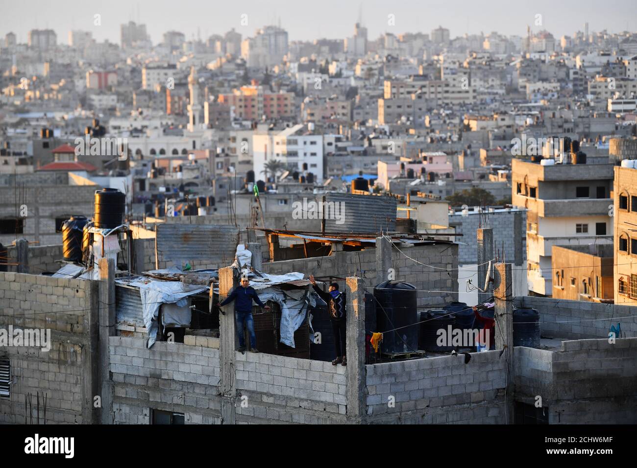 Youngsters play on their apartment roof as the sun sets on Gaza City, February 12, 2019. The Gaza Strip is swathed in beautiful light, and enjoys spectacular sunsets and sunrises. Just 25 miles long and a few miles wide, it is home to nearly 2 million Palestinians, around two-thirds of them refugees. REUTERS/Dylan Martinez  SEARCH 'MARTINEZ GAZA' FOR THIS STORY. SEARCH 'WIDER IMAGE' FOR ALL STORIES. Stock Photo