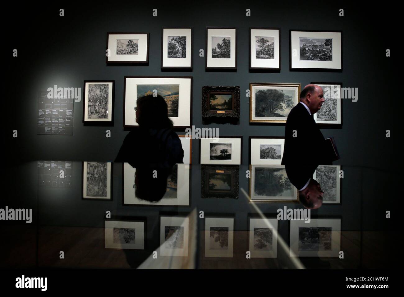 Visitors are reflected as they walk past prints of various artists during the press view of the 'Constable The Making of a Master' exhibition at the V&A museum in London September 17, 2014. REUTERS/Stefan Wermuth (BRITAIN - Tags: SOCIETY) Stock Photo