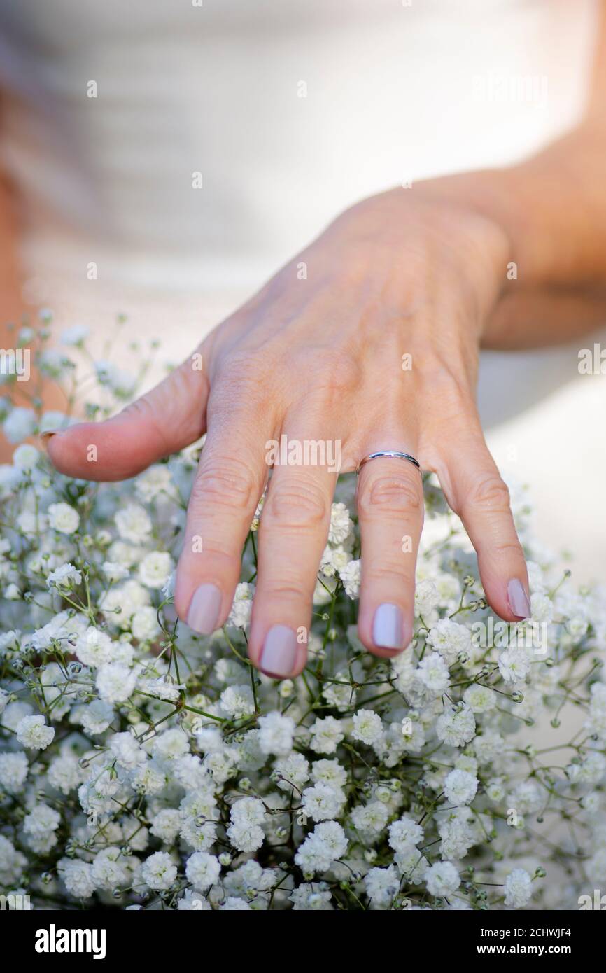 Brides hand with wedding ring resting on flowers Stock Photo Alamy