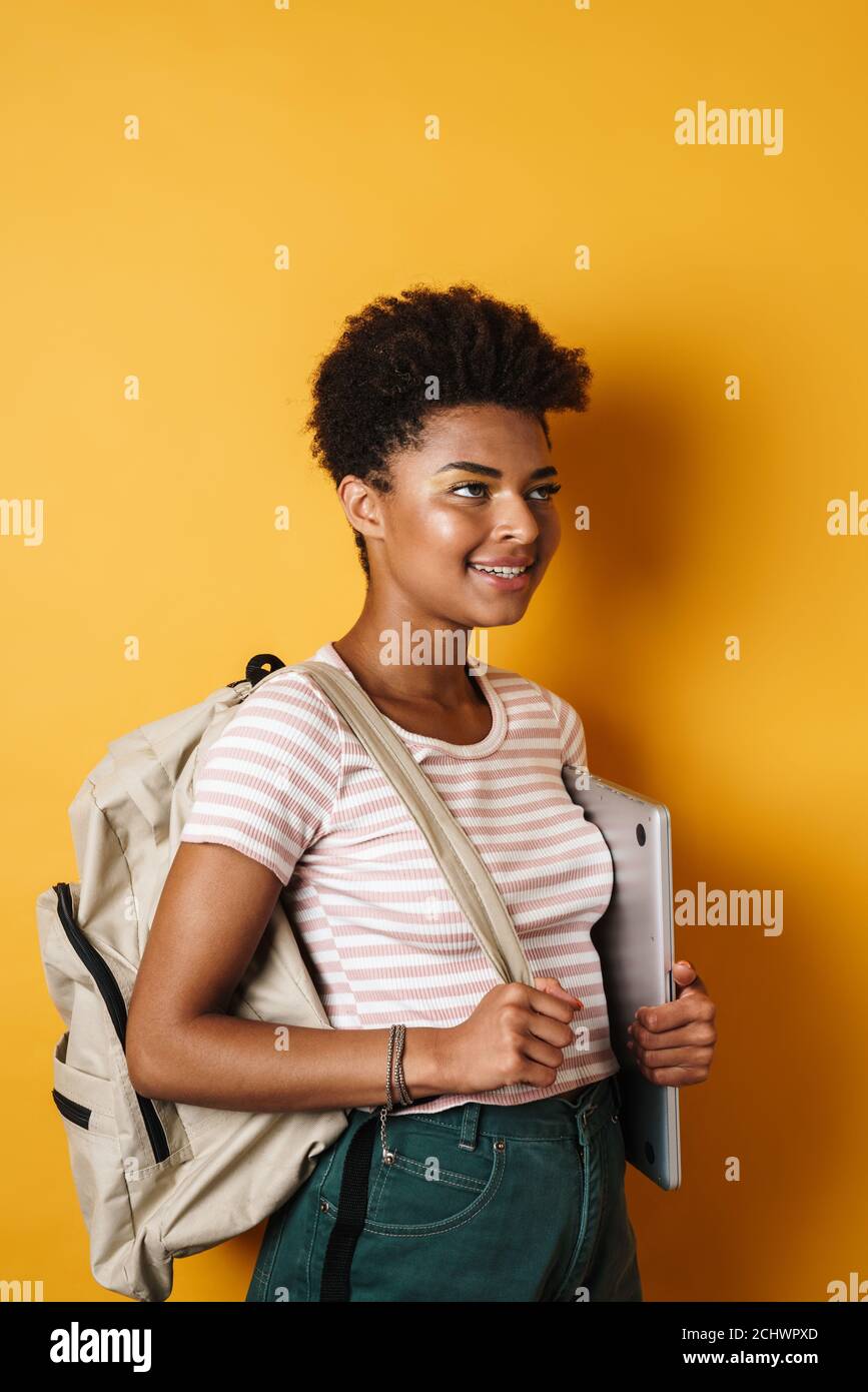 Image of cheerful african american woman holding laptop while smiling ...