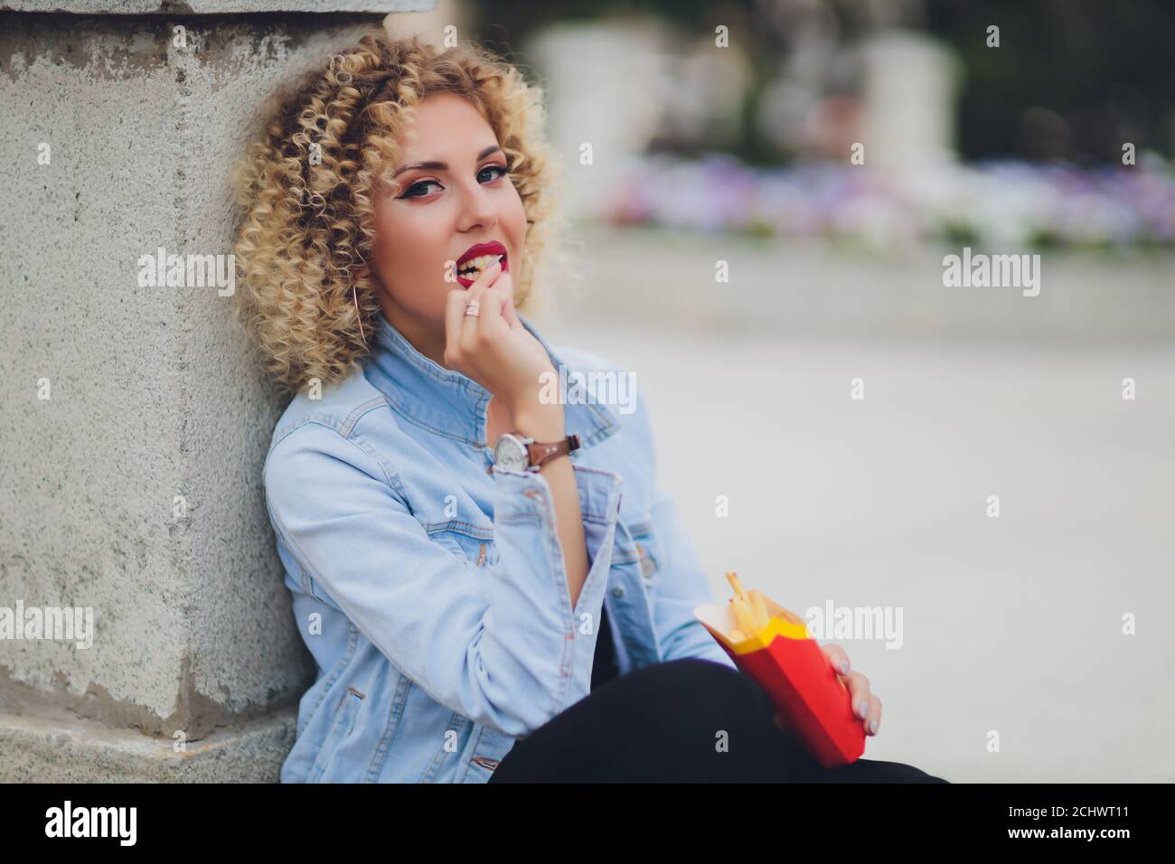 Young Woman Eating A French Fries Street food. Stock Photo