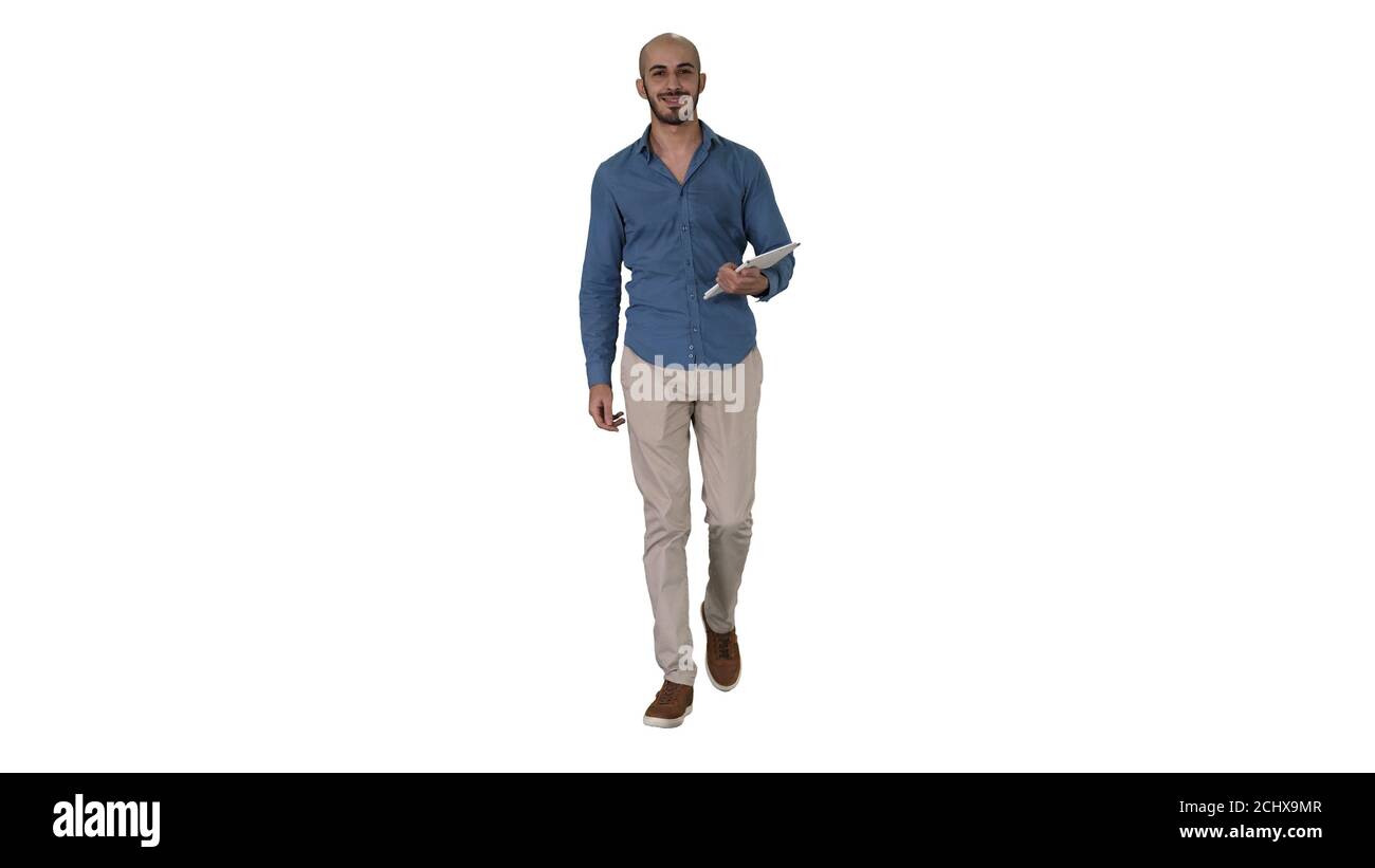 Arab presenter walking with digital tablet swiping pages on it on white background. Stock Photo