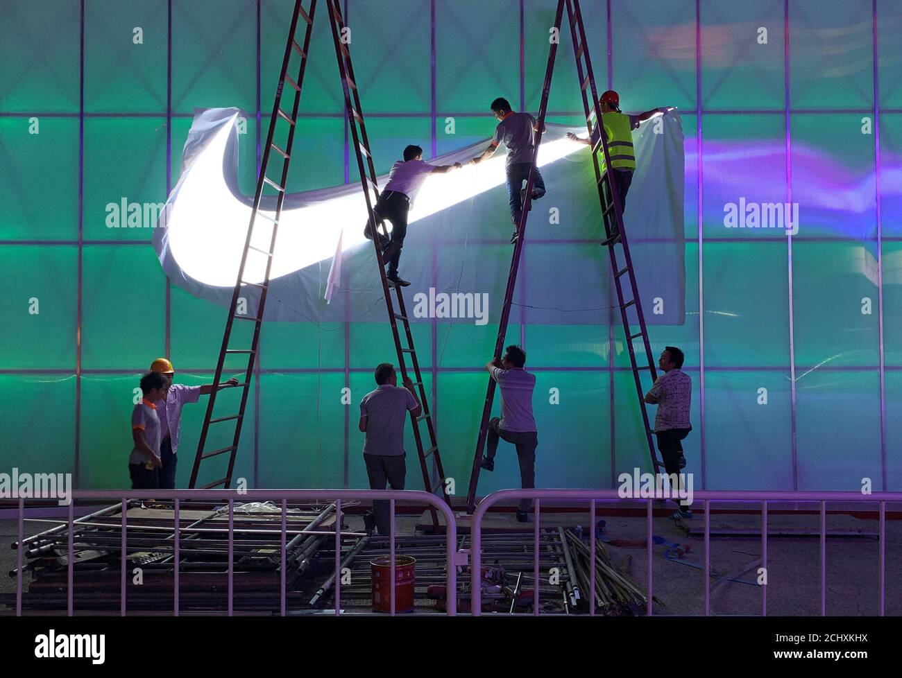 Workers install a Nike logo lamp outside the Wukesong Arena in Beijing,  China August 28, 2019. Picture taken August 28, 2019. REUTERS/Tingshu Wang  Stock Photo - Alamy