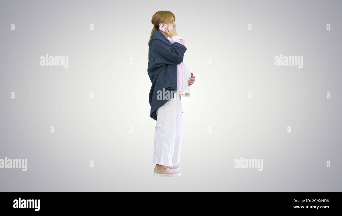 Attractive pregnant woman making phone call and holding her tumm Stock Photo