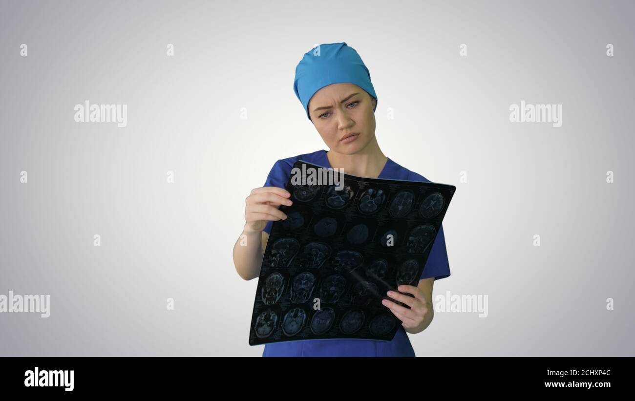 Female doctor looking at brain tomography on gradient background Stock Photo