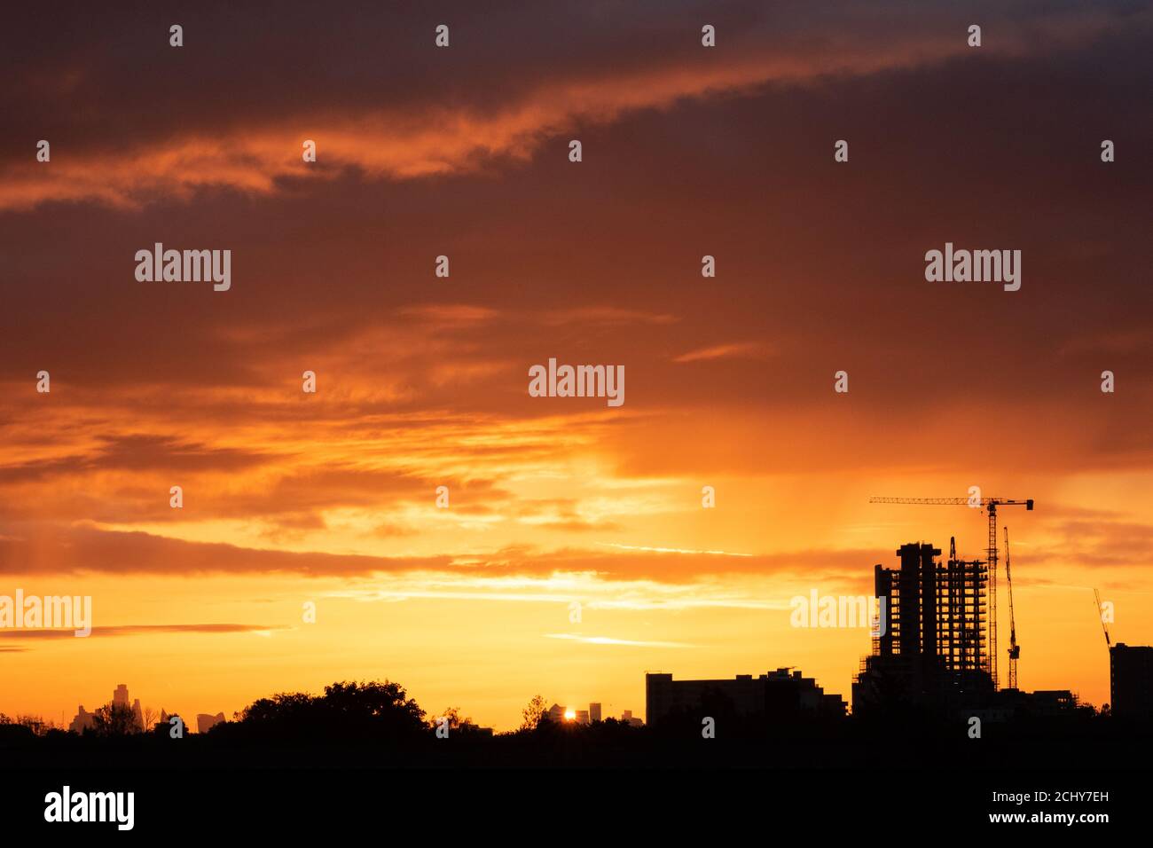 The sun rises over an urban skyline in west London Stock Photo