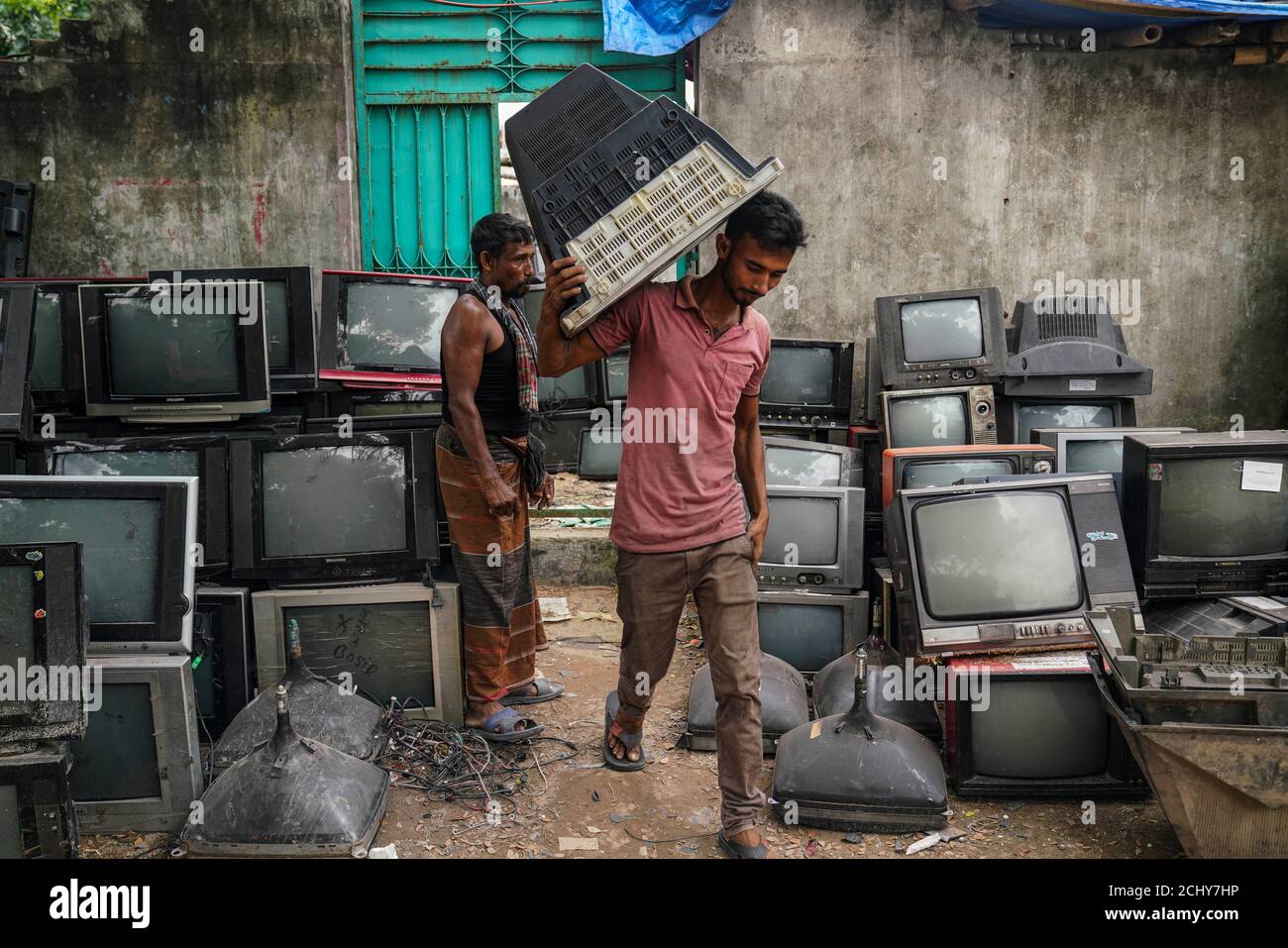 A worker is seen sorting TV for recycle at a TV recycling scrap yard in