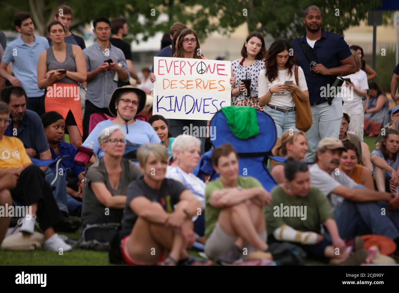 People sit and hold signs during an immigration rights rally at Cleveland Square Park in El Paso, Texas, U.S. July 12, 2019. REUTERS/Daniel Becerril Stock Photo