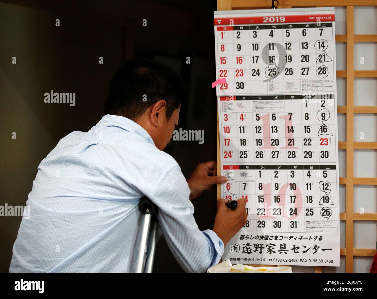 Masaaki Kimura, 63, circles the dates of the Rugby World Cup matches that he will attend at Kamaishi Recovery Memorial Stadium in Unosumai, Japan September 24, 2019. Kamaishi stadium was built on the former site of two schools which was destroyed by the 2011 tsunami. Masaaki lost his wife who was a schoolteacher in one of the schools that day.  REUTERS/Edgar Su Stock Photo