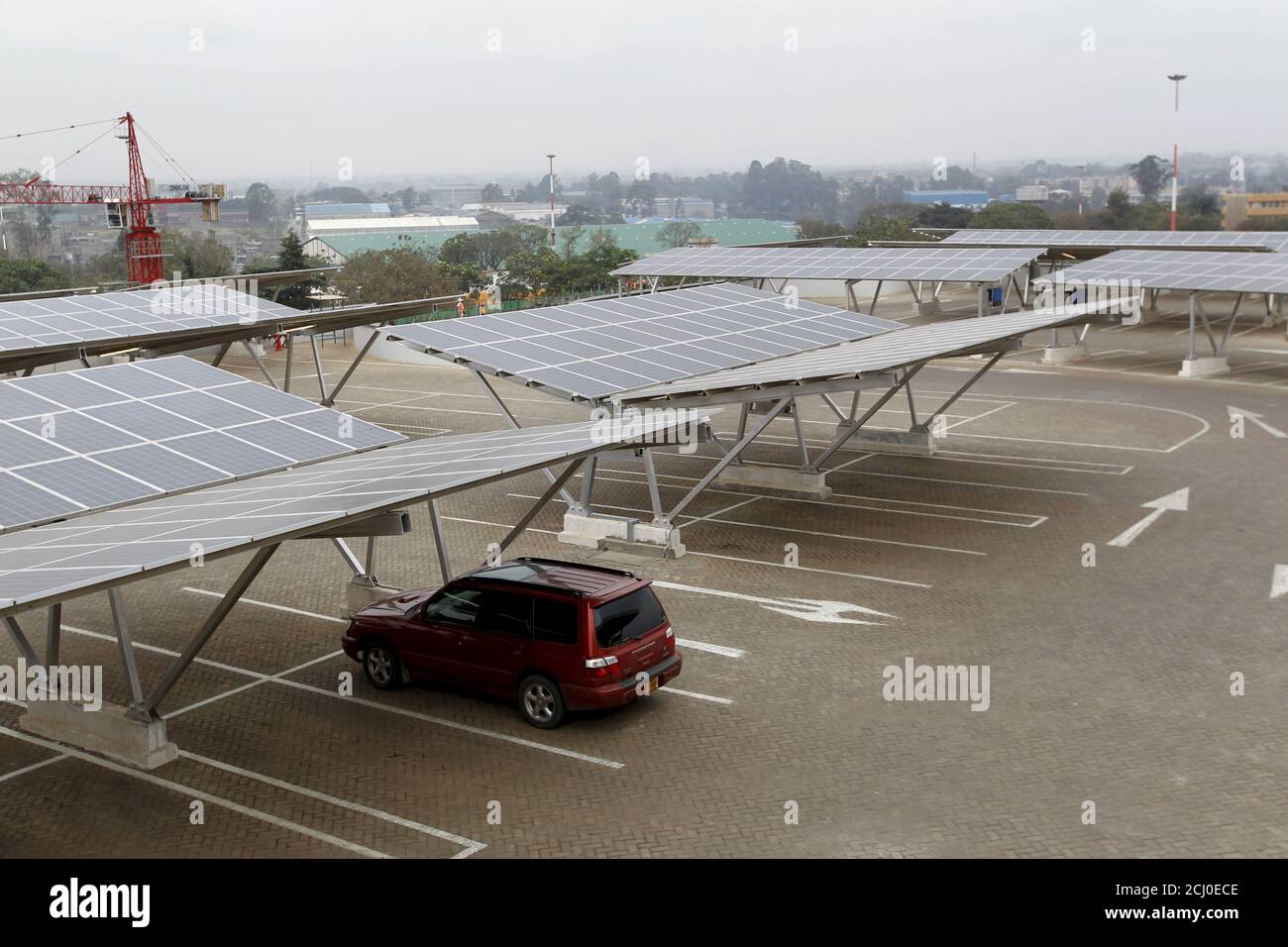 A car is seen parked under solar panels at a solar carport at the Garden City shopping mall in Kenya's capital Nairobi, September 15, 2015. The Africa's largest solar carport with 3,300 solar panels will generate 1256 MWh annually and cut carbon emission by around 745 tonnes per year, according to Solarcentury and Solar Africa.  REUTERS/Thomas Mukoya Stock Photo