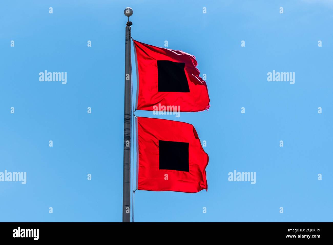 Hurricane warning flags flying in a strong wind. Stock Photo