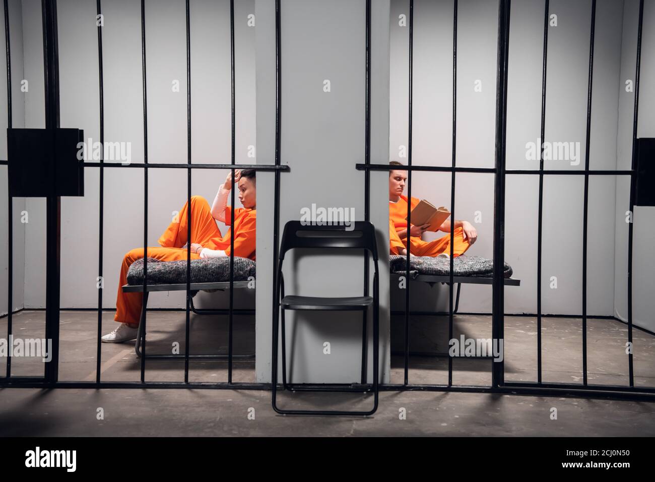 Prisoners in their cells are bored before lights out in prison. Read