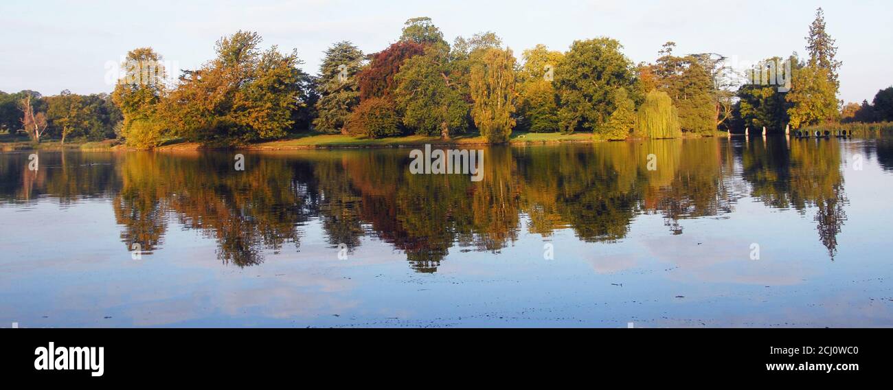 Autumn Panorama of Capability Brown's lake at Burghley where the variety of plantin in ther pleasure ground takes the eye off Brown's extensive dam Stock Photo