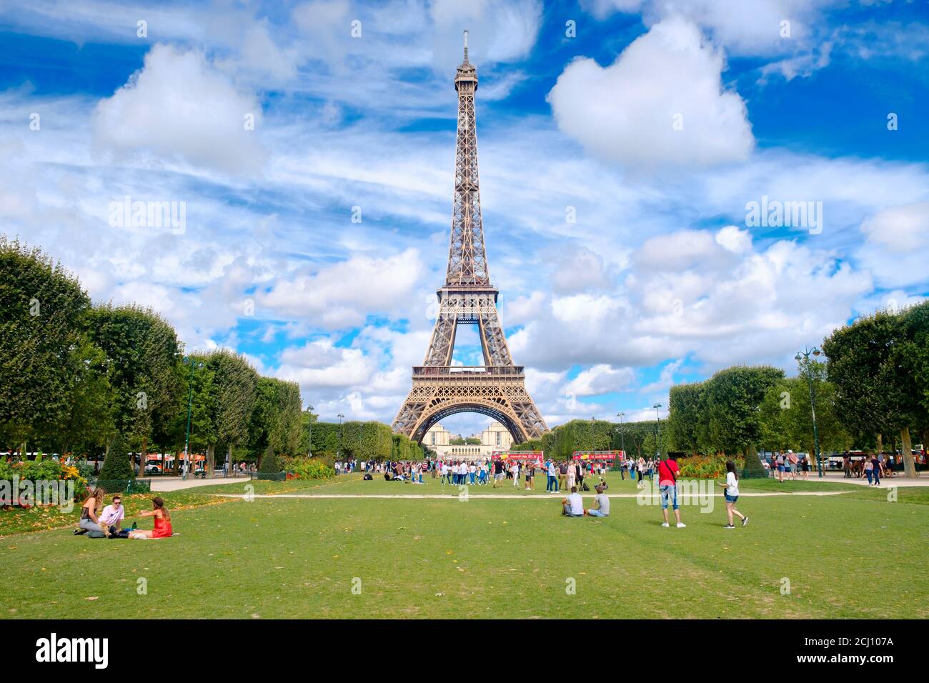 The Eiffel Tower and tourists  at the Champ de Mars on a beautiful summer day in Paris Stock Photo