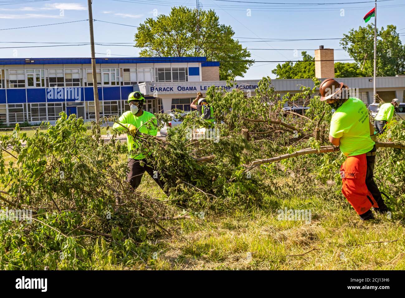 Detroit, Michigan - Workers from the Detroit Grounds Crew clear overgrown brush on a vacant lot next to a school. Stock Photo