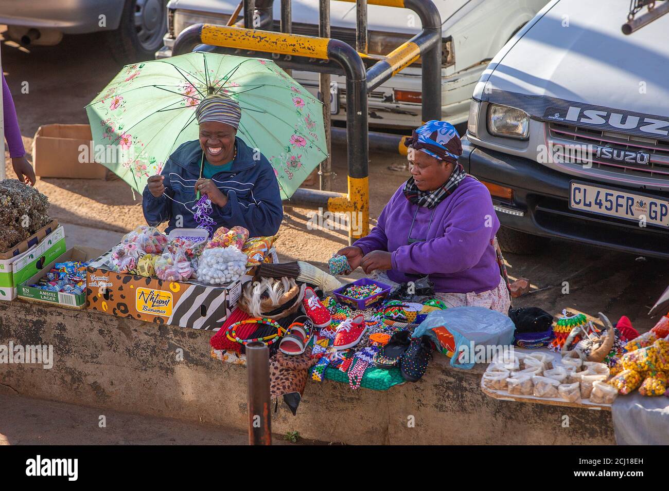 Two African ladies selling wares at a market stall at the Soweto taxi rank, South Africa Stock Photo