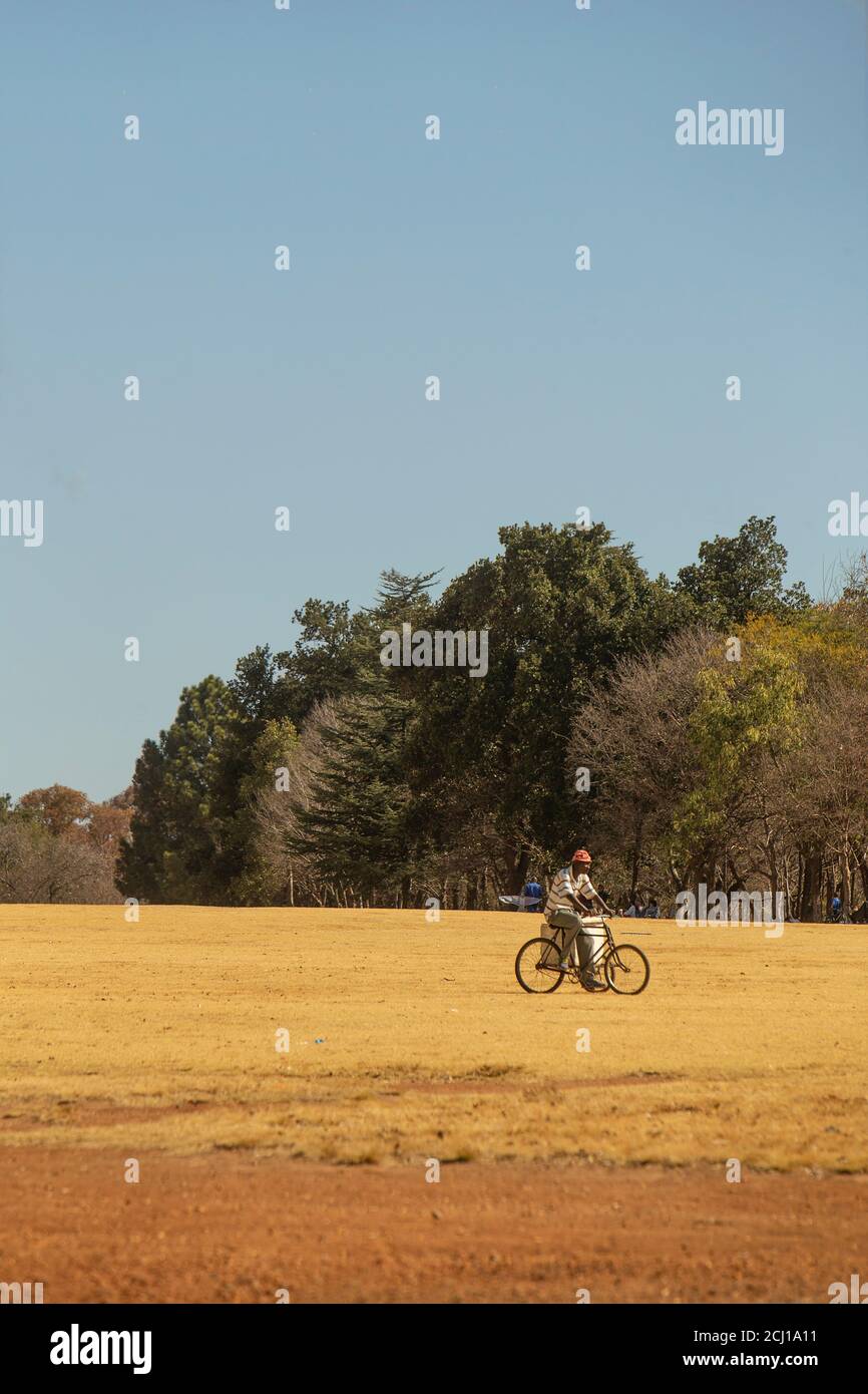 African man cycling at Emmarentia Dam, Johannesburg, South Africa Stock