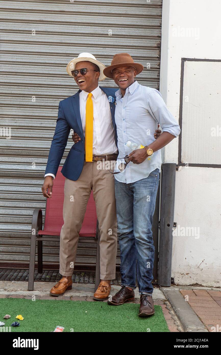 Two well-dressed African men hugging and laughing Stock Photo