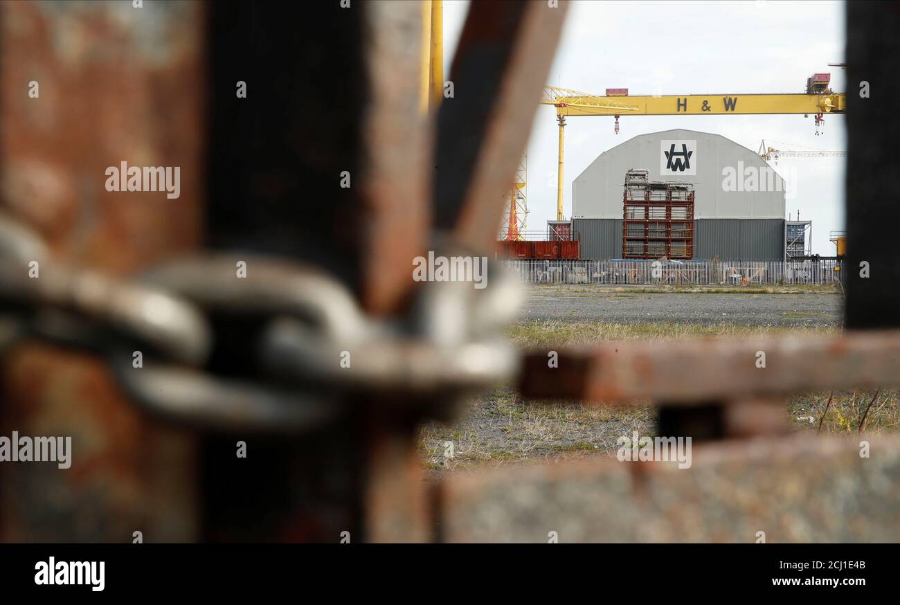 A gantry crane is seen through locked gates in the shipyard of Harland & Wolff Heavy Industries in Belfast, Northern Ireland September 6, 2019. REUTERS/John Sibley Stock Photo