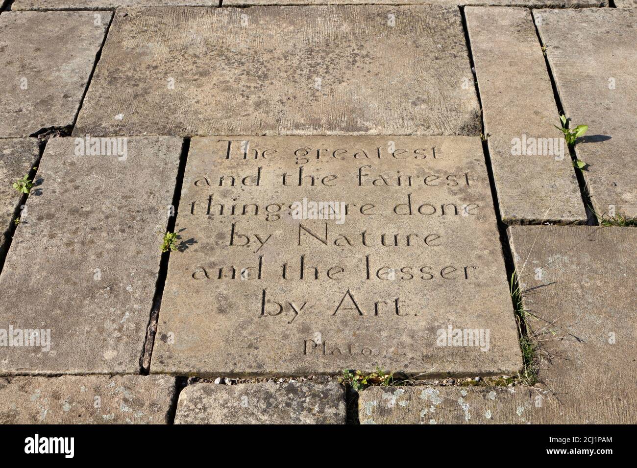 The greatest and fairest things are done by nature and the lesser by art, quote by Plato, on paving slab, in a garden of remembrance Stock Photo
