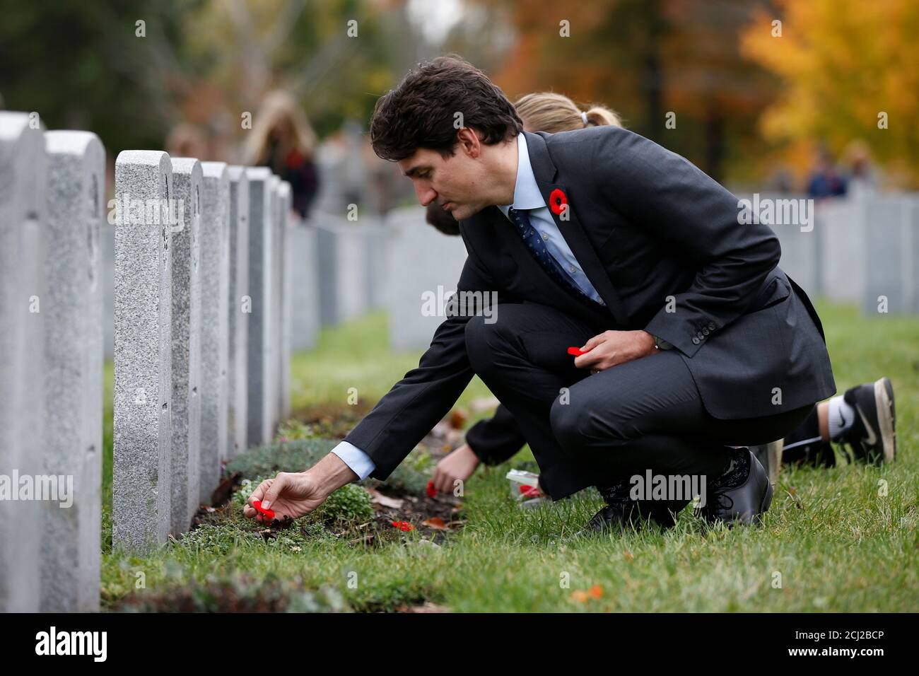 Canada's Prime Minister Justin Trudeau places a poppy at a grave during an event to mark the upcoming Veterans' Week and 100th anniversary of the Battle of Passchendaele at the National Military Cemetery in Ottawa, Ontario, Canada, November 3, 2017. REUTERS/Chris Wattie Stock Photo