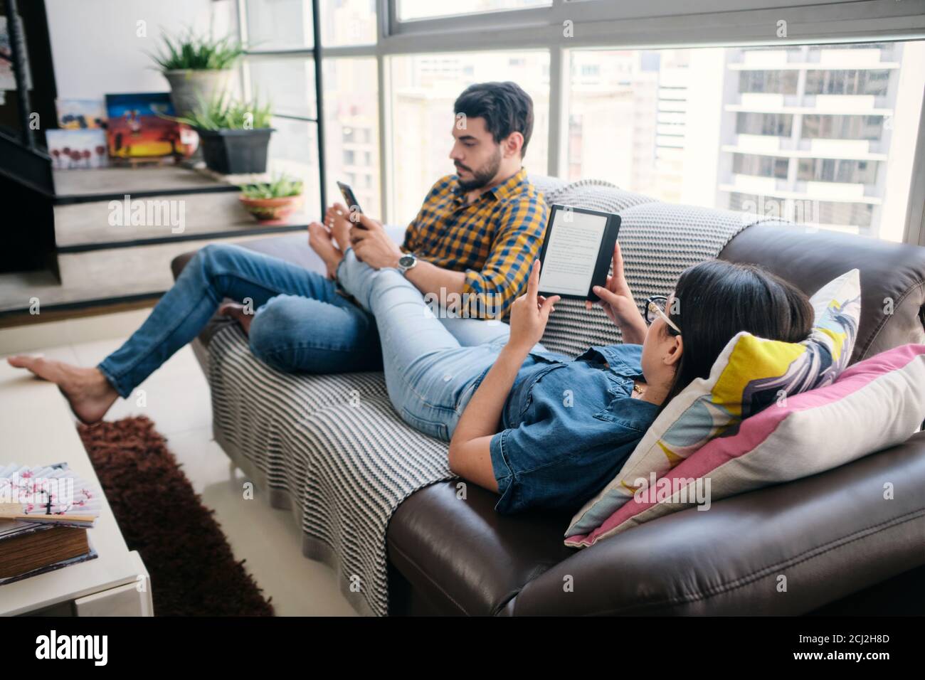Young Couple Holding Ereader And Reading Ebook Stock Photo
