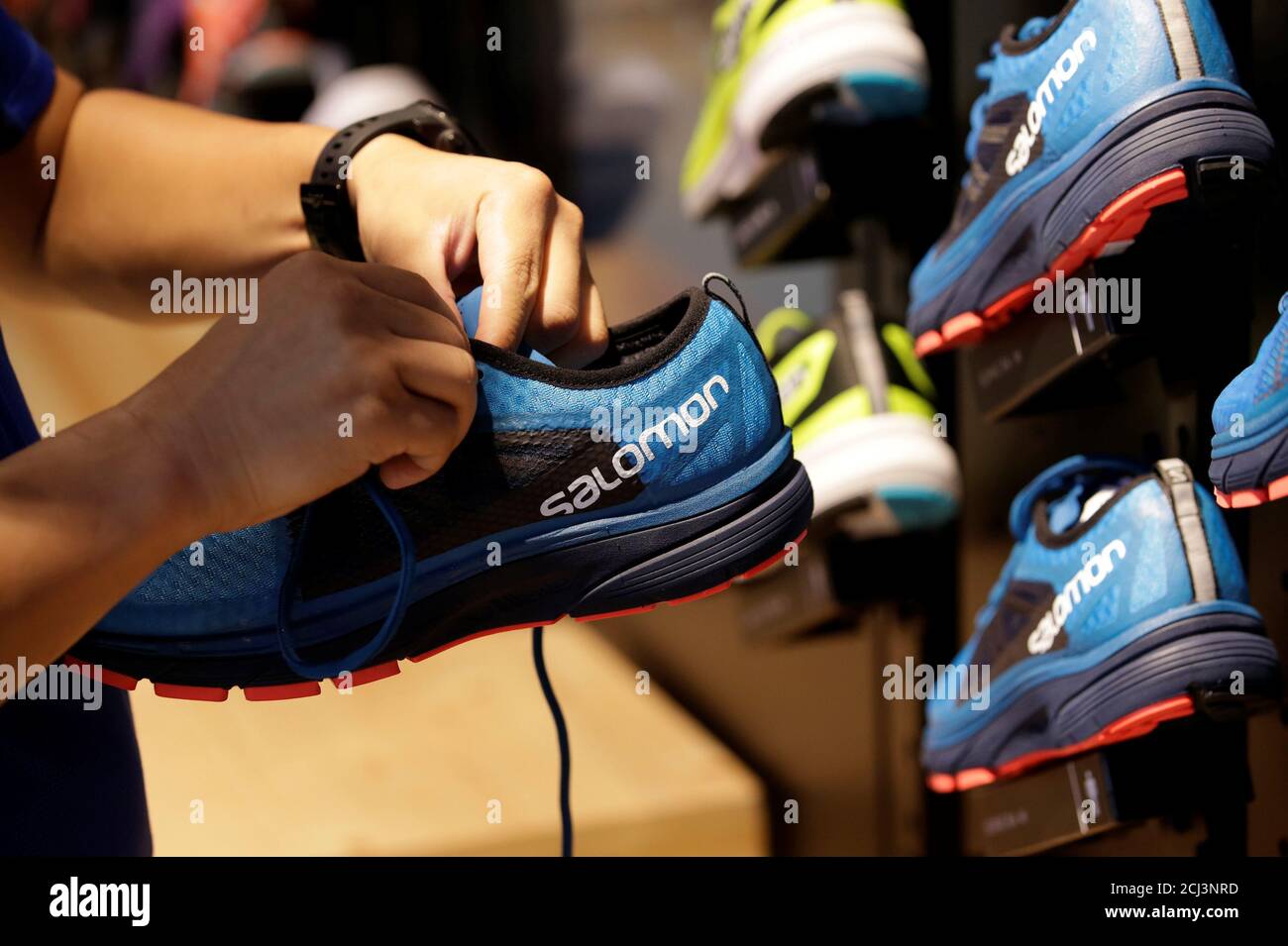 A shop assistant holds a shoe at a Salomon store in Beijing, China August  10, 2018. Picture taken August 10, 2018. REUTERS/Jason Lee Stock Photo -  Alamy