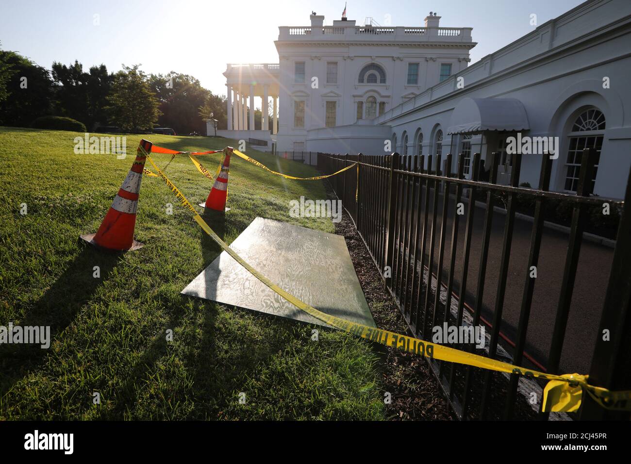 Yellow caution tape and cones are seen around a sinkhole next to the entrance of the briefing room at the White House in Washington, U.S., May 23, 2018. REUTERS/Carlos Barria Stock Photo