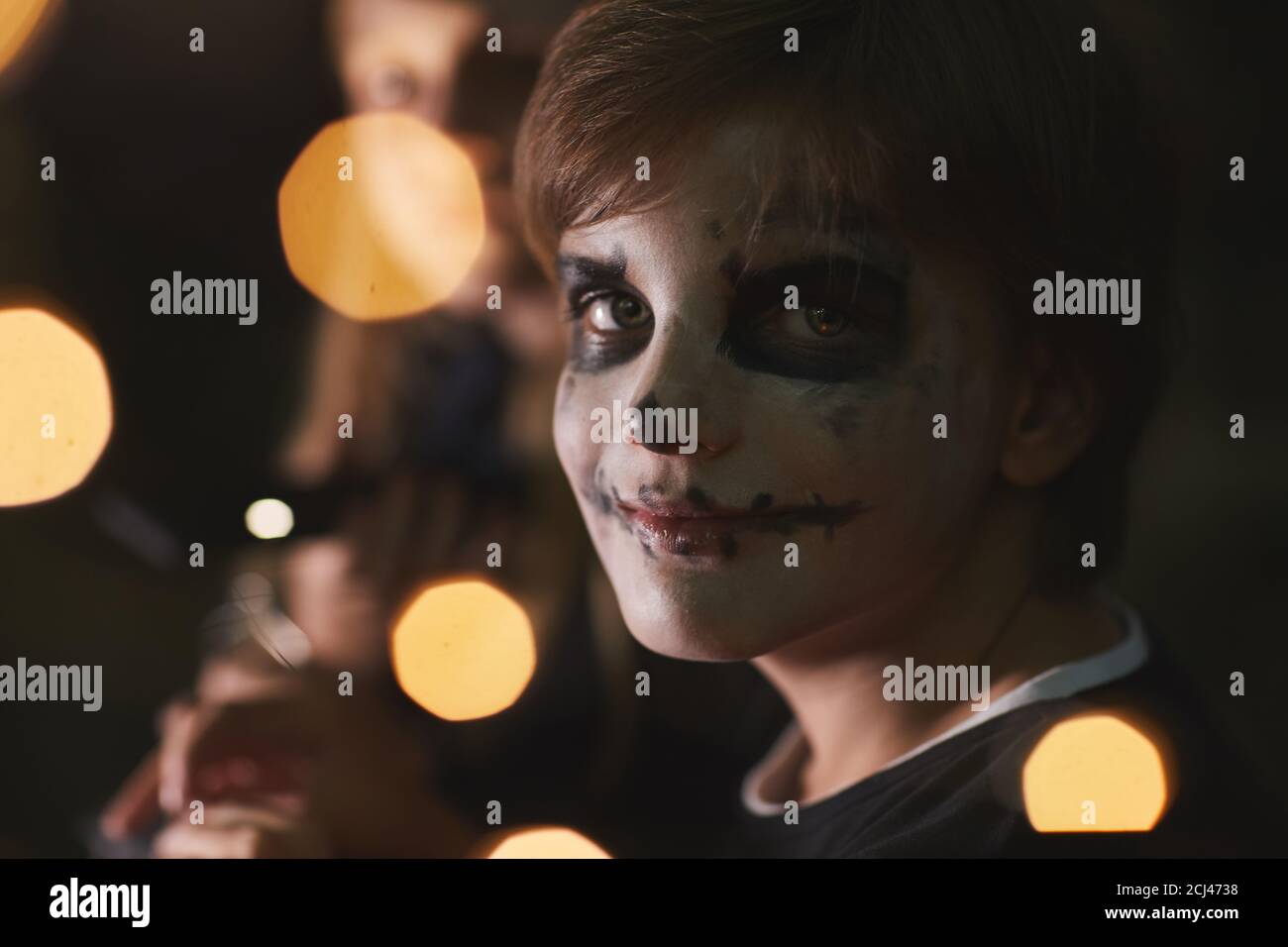 Portrait of teenage boy wearing face paint and looking at camera during  outdoor Halloween party with lights , copy space Stock Photo - Alamy