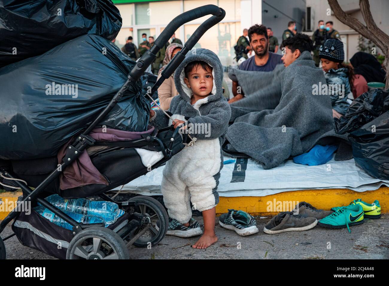 Little children are among the refugees sleeping on roadside after Moria fire.More than 13,000 Asylum seekers  flee fire at Greece's largest migrant Moira camp at lesbos. They have been stranded on the street before the town of mitilini and prevented to enter the harbour by police. Stock Photo
