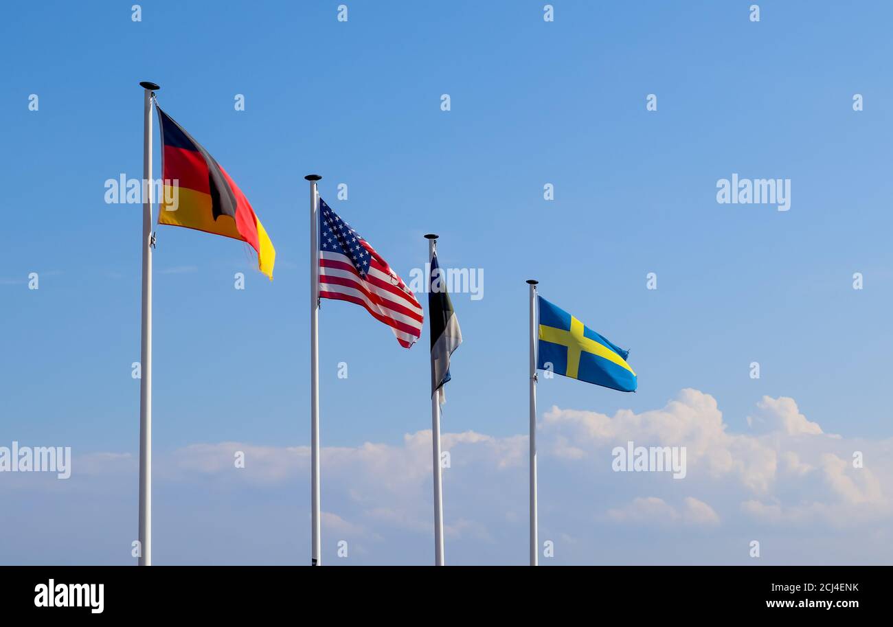 Row of flags on poles waving in the sky Stock Photo - Alamy
