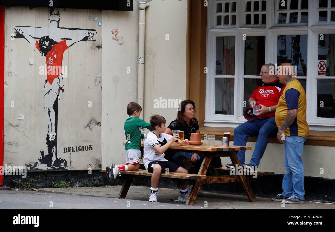Soccer Football - Championship - Bristol City v - Ashton Gate Stadium, Bristol, Britain - September 2, 2018 Fans next to a Banksy on the a shop in
