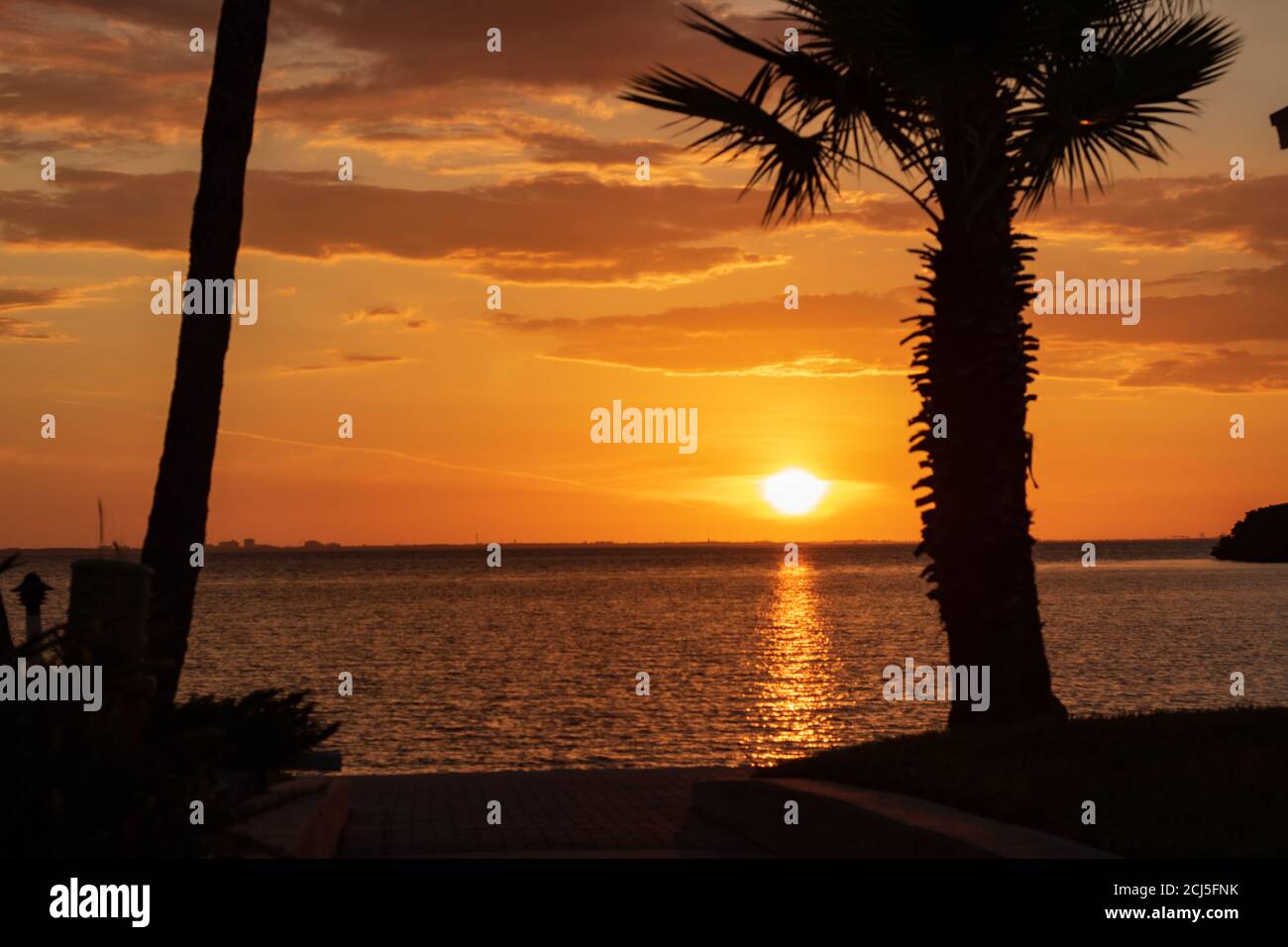 Beautiful scenery of the sunset reflecting in the sea surrounded by ...