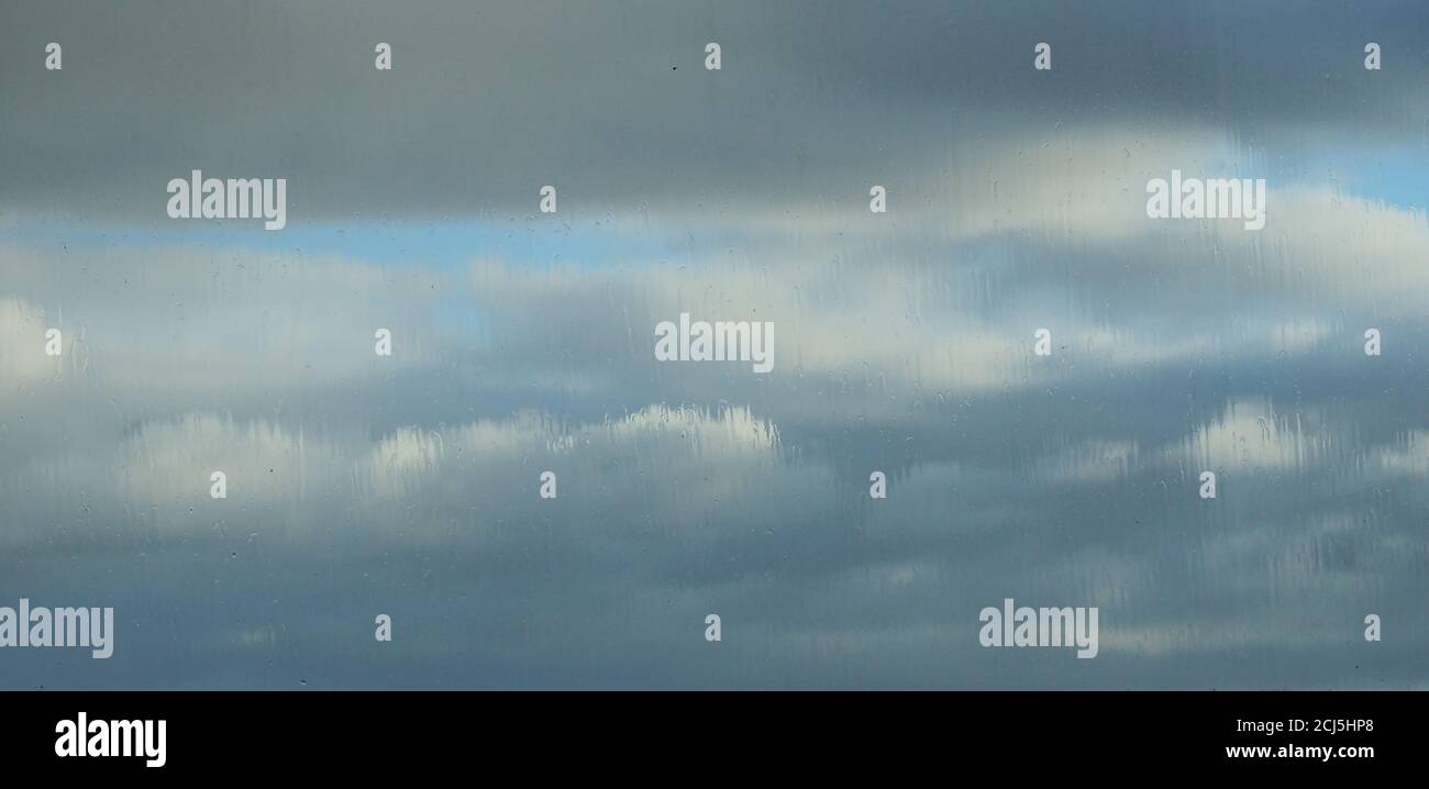 Storm clouds through rain on a double glazed uPVC window Stock Photo