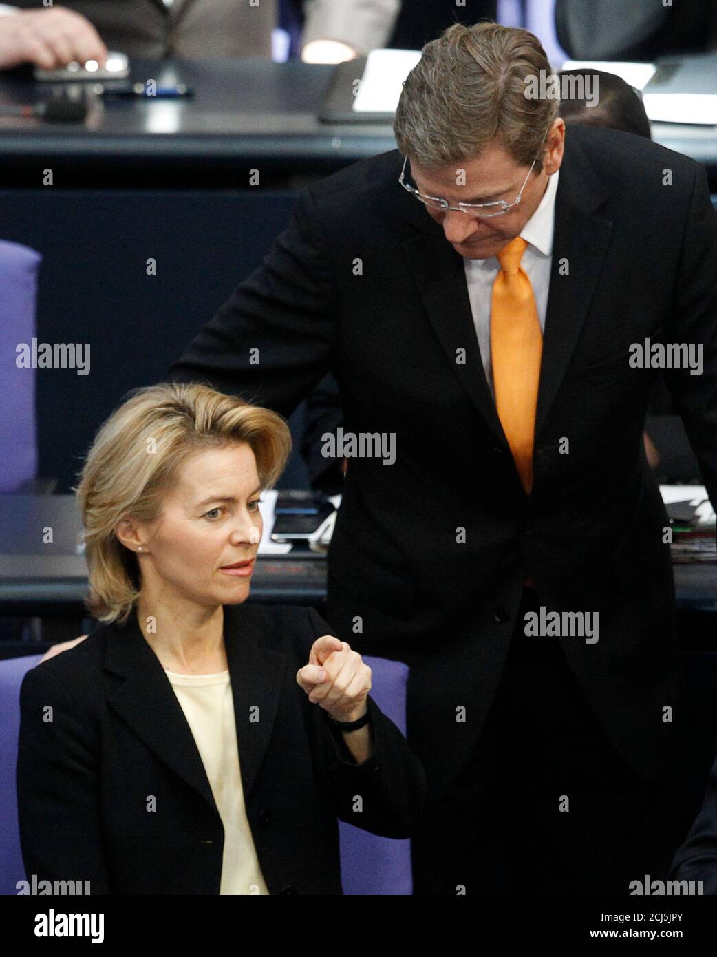 German Foreign Minister and Vice-Chancellor Guido Westerwelle (R) talks with Labour Minister Ursula von der Leyen before debate about the Hartz VI unemployment benefits in the Bundestag lower house of parliament in Berlin February 25, 2010.  REUTERS/Thomas Peter (GERMANY - Tags: POLITICS) Stock Photo