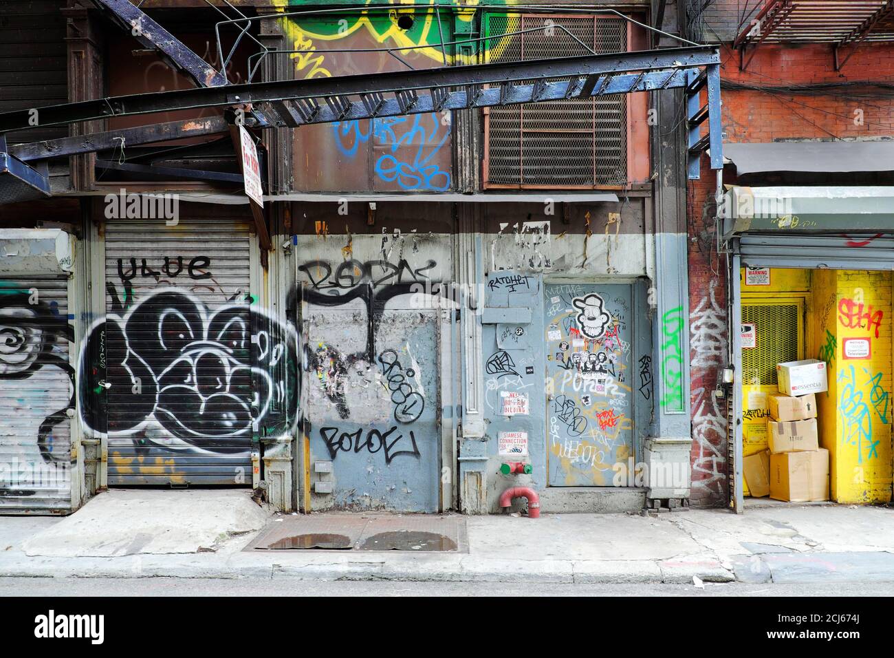 A side street at Manhattan's Chinatown. Intervened by street artists, giving to it color and making interesting to stop for see and captured. Stock Photo
