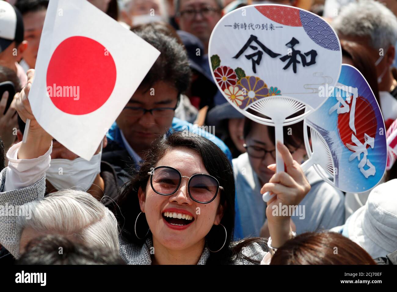 A Woman Waves A Japanese Flag And Paper Fans With The Name Of The New Imperial Era Reiwa Printed On Them Before The First Public Appearance Of Japan S Emperor Naruhito And Empress