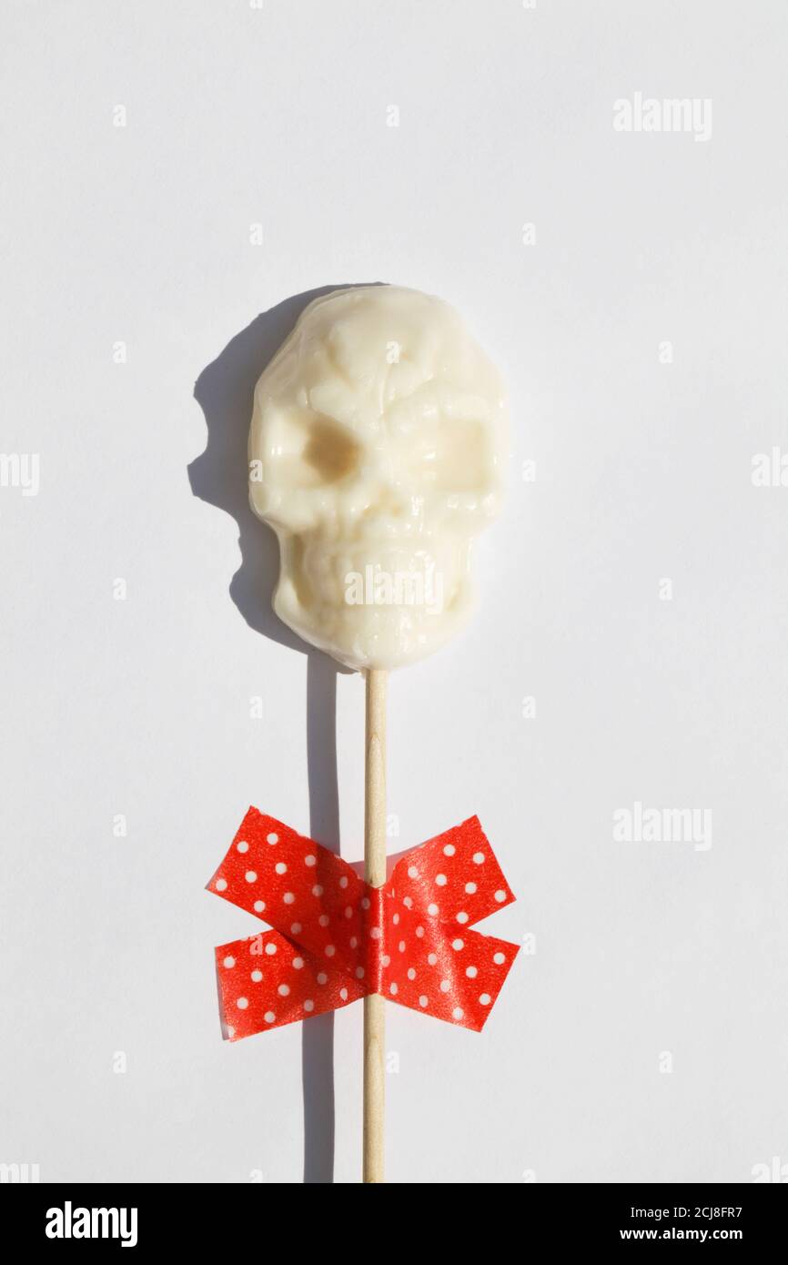 white lollipop in form of skull on white background. Creative Halloween