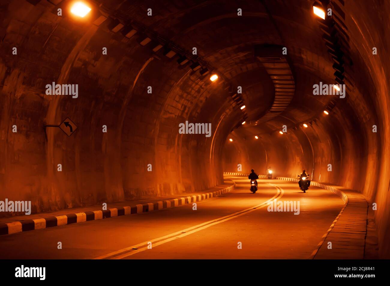 Motion blur, Asian people riding motorcycles in a dark tunnel at night. Stock Photo