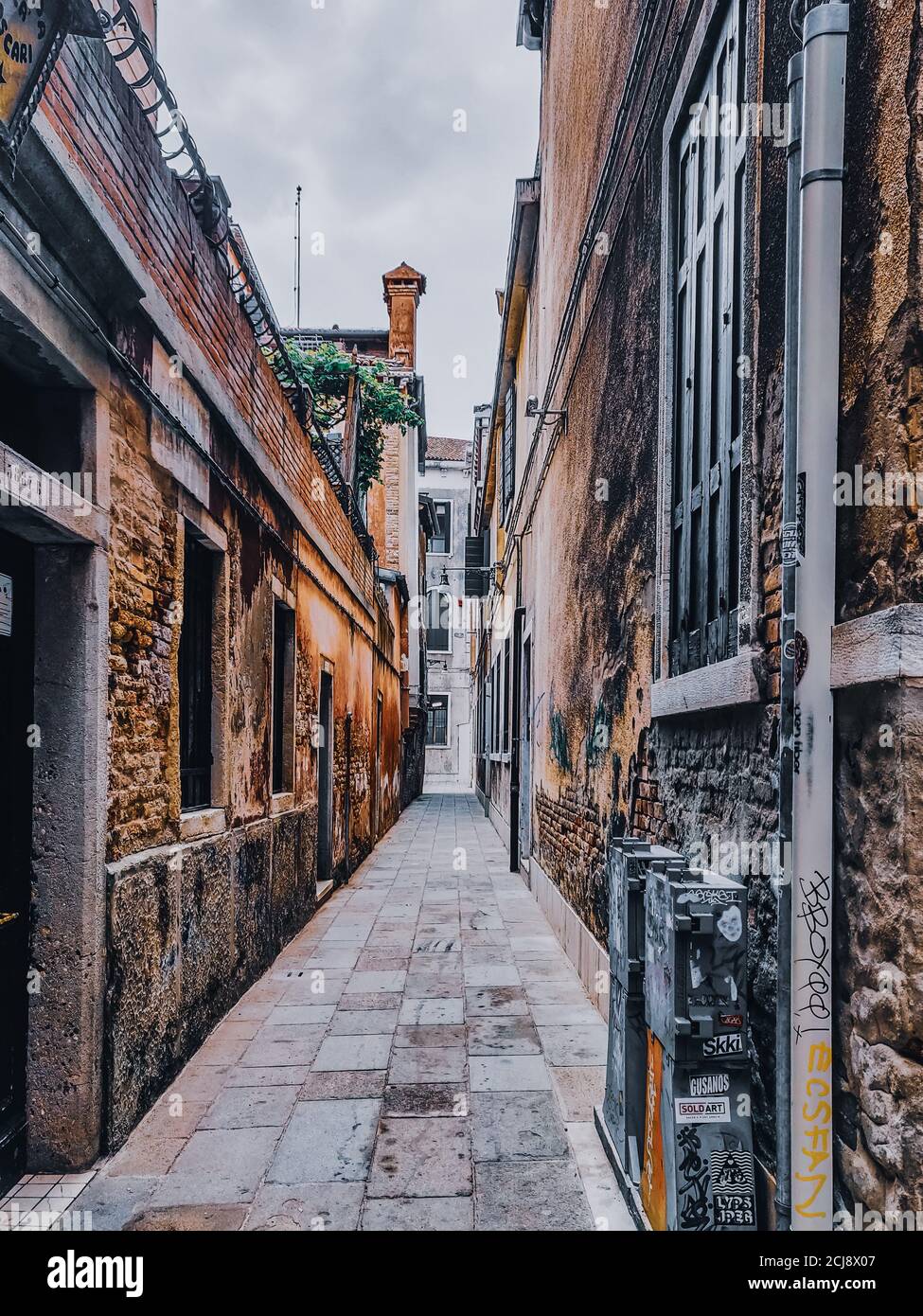 Vertical shot of a narrow route between the buildings Stock Photo - Alamy