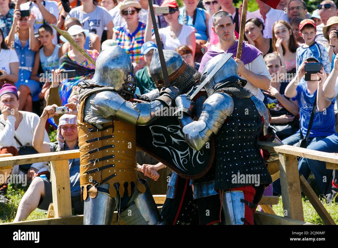 Knight Tournament. Medieval restorers fight with swords in armor at a ...