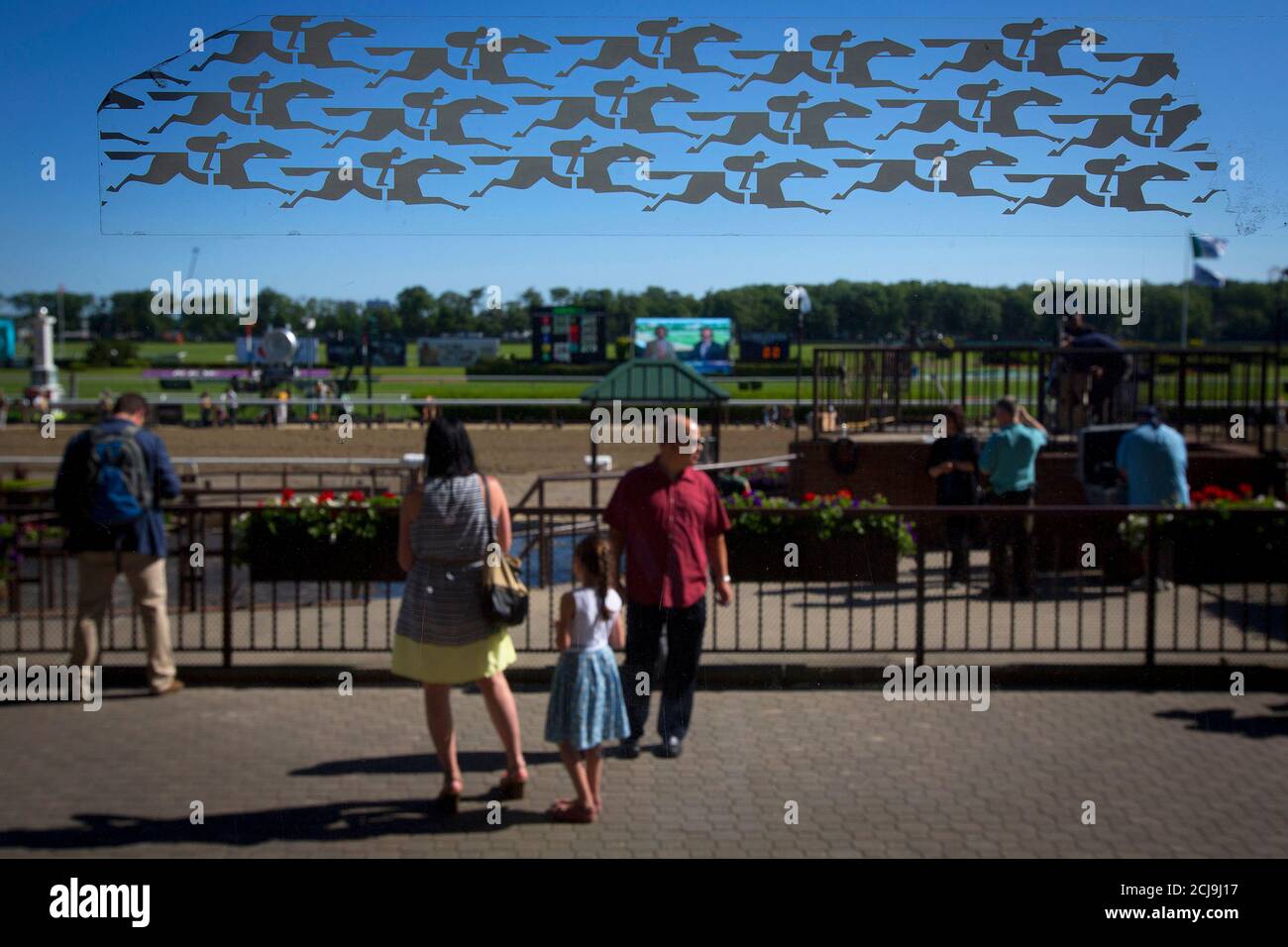 Horseracing stickers are pictured on a window of the grandstand as people walk past, before the 2014 Belmont Stakes in Elmont, New York June 7, 2014.   REUTERS/Carlo Allegri (UNITED STATES - Tags: SPORT HORSE RACING) Stock Photo