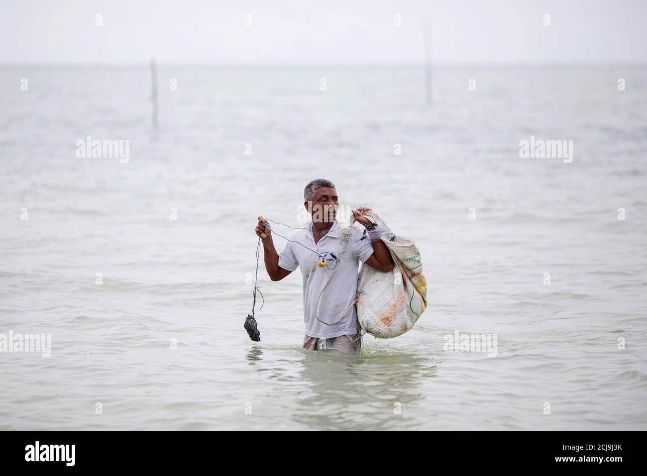 Hong Klathalay walks towards his fishing boat in Khao Lak, Phang Nga province December 14, 2014. Hong Klathalay, a 48-year-old community leader in the ethnic Moklen village of Thung Wa in Phang Nga province, said the tsunami put an abrupt stop to tourism development, granting them unfettered access to the sea and time to resume their traditional way of life. With tourism making a comeback in the area, the Moklens fear their way of life on the coast, with the sea, is on the brink of extinction. Picture taken  December 14, 2014.  REUTERS/Damir Sagolj (THAILAND - Tags: SOCIETY BUSINESS AGRICULTUR Stock Photo