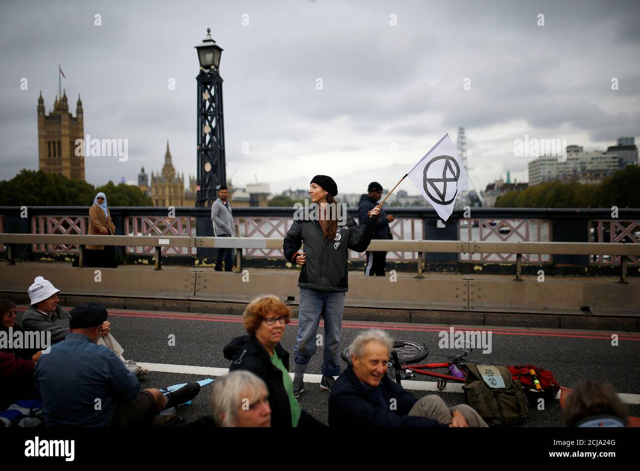 An activist holds a flag with the extinction symbol at Lambeth Bridge during the Extinction Rebellion protest in London, Britain October 7, 2019. REUTERS/Henry Nicholls Stock Photo