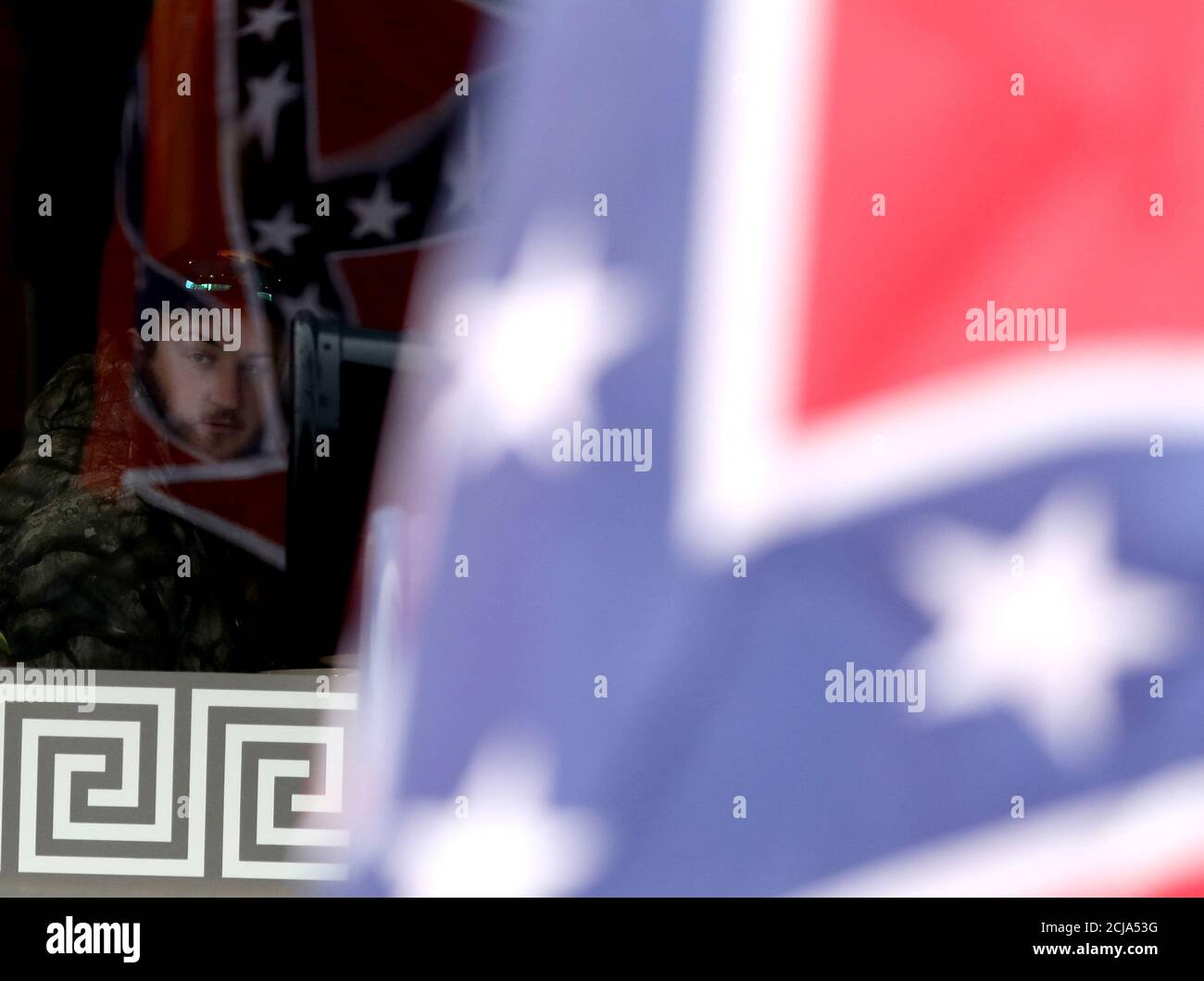 A man watches from a diner as supporters of the continued display of Confederate generals’ statues and other symbols march with Confederate flags in Lexington, Virginia, U.S. January 18, 2020. REUTERS/Jim Urquhart Stock Photo