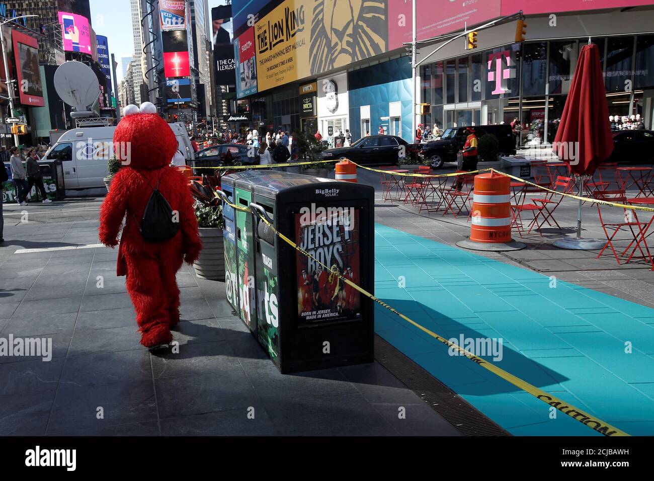 A costumed character dressed as Elmo who poses for tips walks past a newly painted a-costumed-character-dressed-as-elmo-who-poses-for-tips-walks-past-a-newly-painted-designated-activity-zone-in-new-york-s-times-square-u-s-june-9-2016-where-beginning-on-june-21